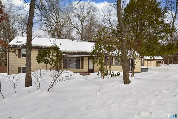a view of a white house with a yard covered in snow
