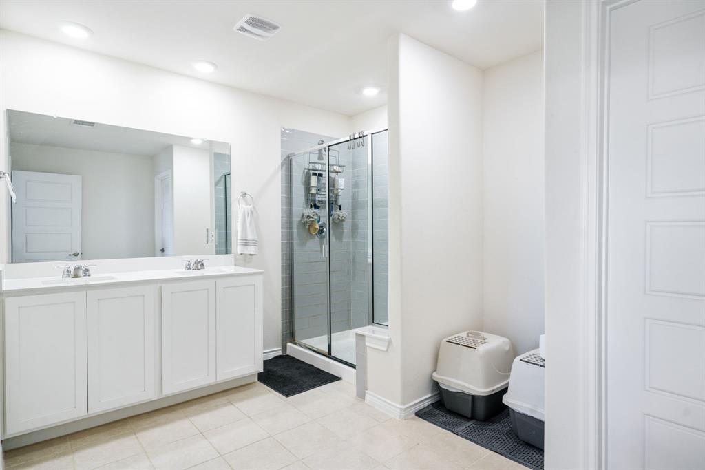 653 Bunker Hill Road Houston, TX 77024 - Photo 18 of 36 Full bath featuring double vanity, a shower stall, and light tile patterned floors