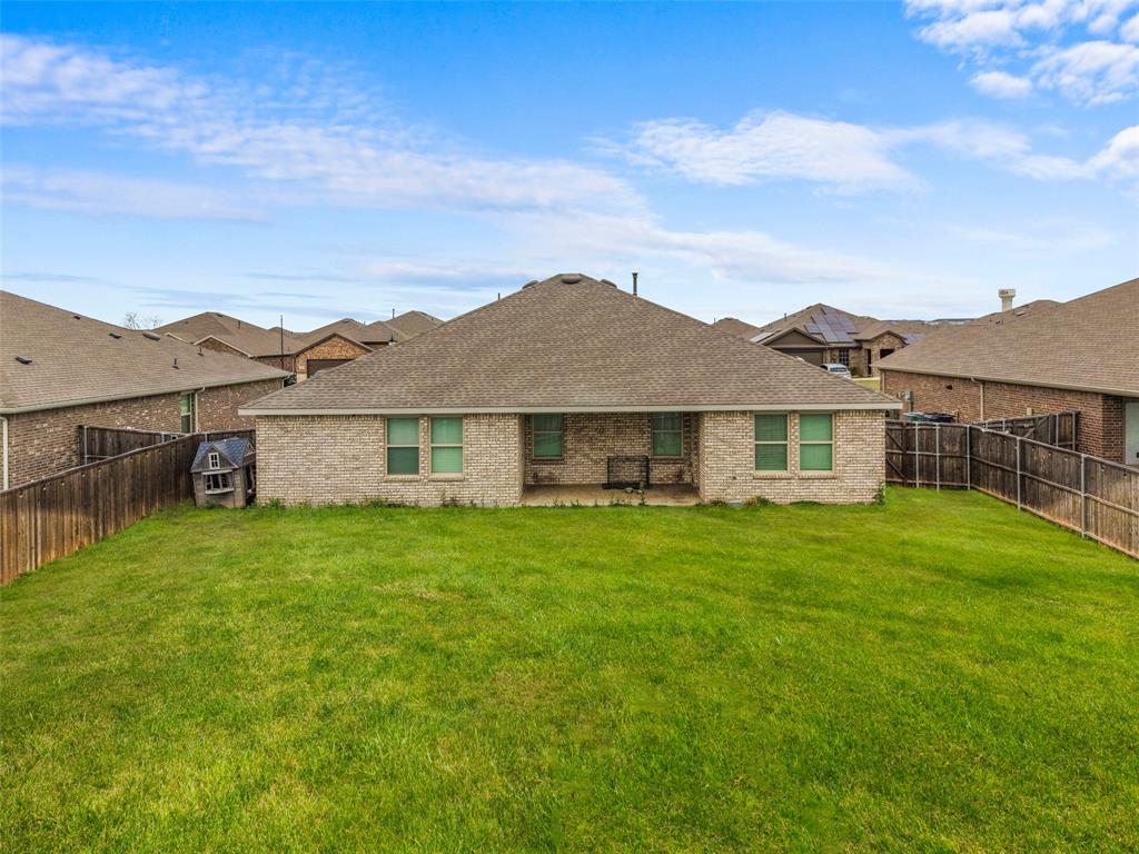 653 Bunker Hill Road Fate, TX 75189 - Photo 28 of 36 Grass has been modified. Back of house with a patio, brick siding, and a fenced backyard