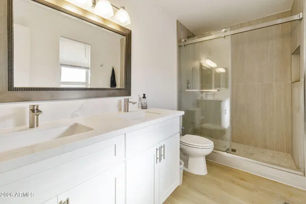 a bathroom with a sink a toilet and shower