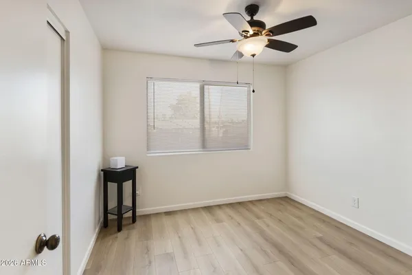 an empty room with a window and a ceiling fan