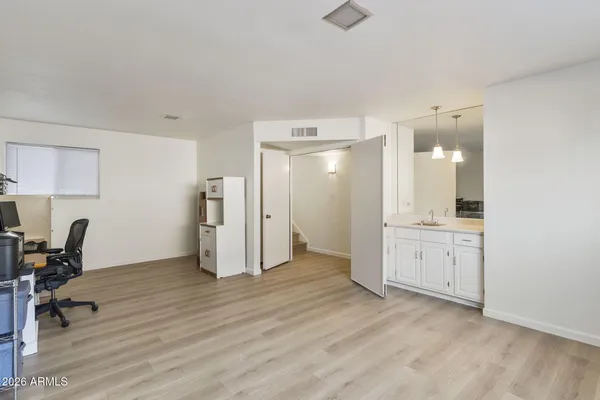 a view of kitchen with a refrigerator wooden cabinets and a sink
