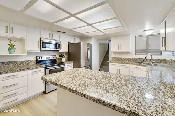 a kitchen with stainless steel appliances granite countertop a sink stove and refrigerator