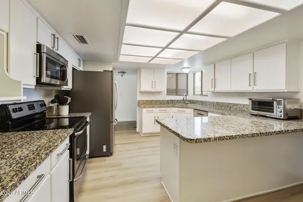 a kitchen with stainless steel appliances granite countertop a sink stove and refrigerator