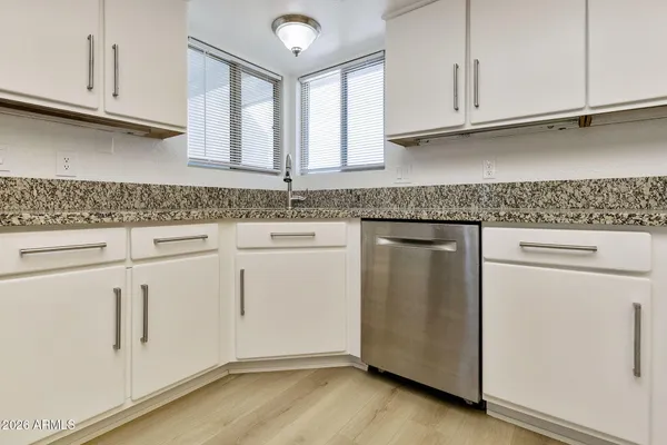 a kitchen with granite countertop white cabinets and a stainless steel appliances