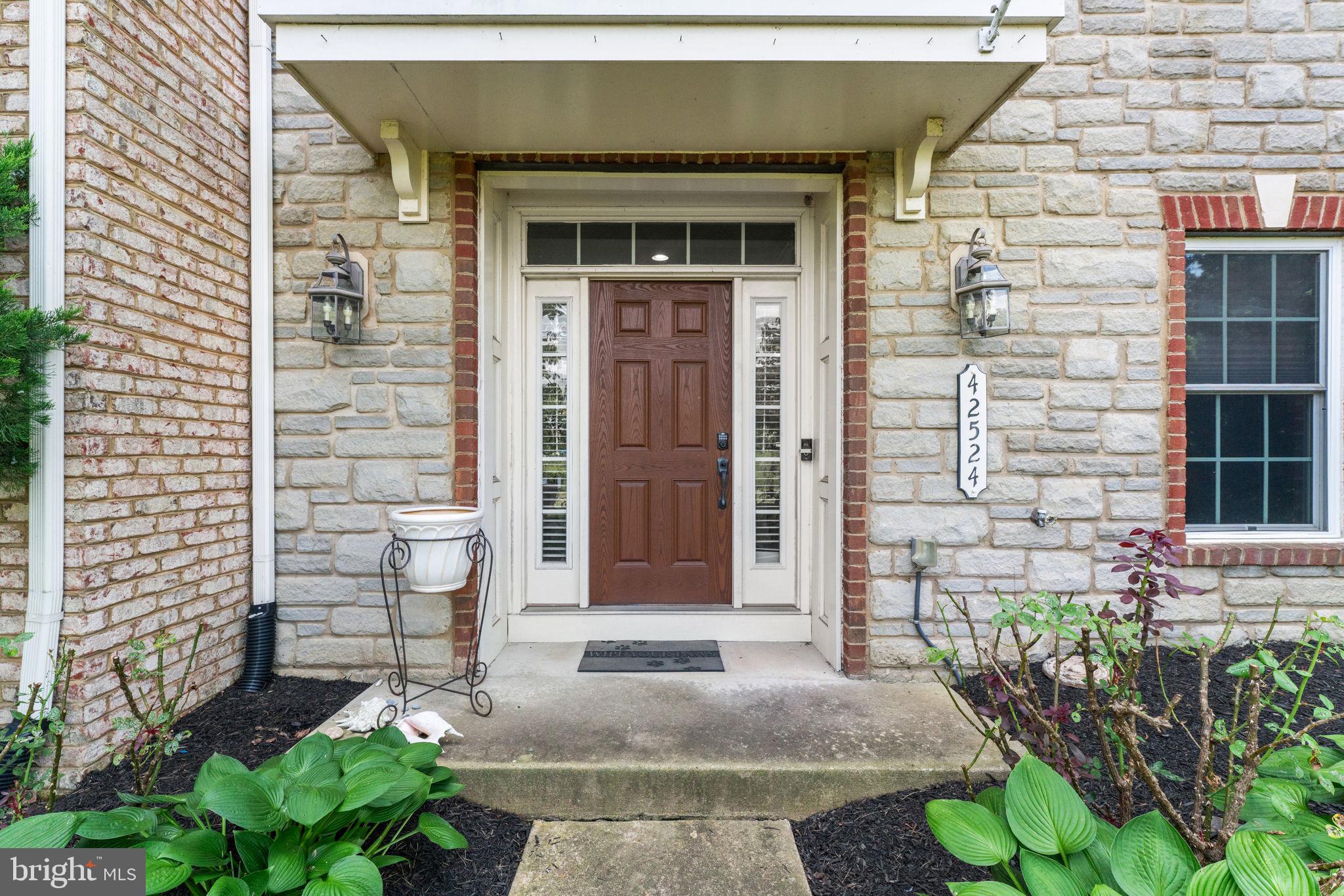 42524 Rowderbury Square Chantilly, VA 20152 - Photo 2 of 73 a front view of a house with a garden
