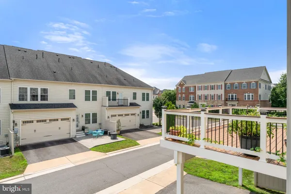 a view of a kitchen with kitchen island wooden floor center island and stainless steel appliances