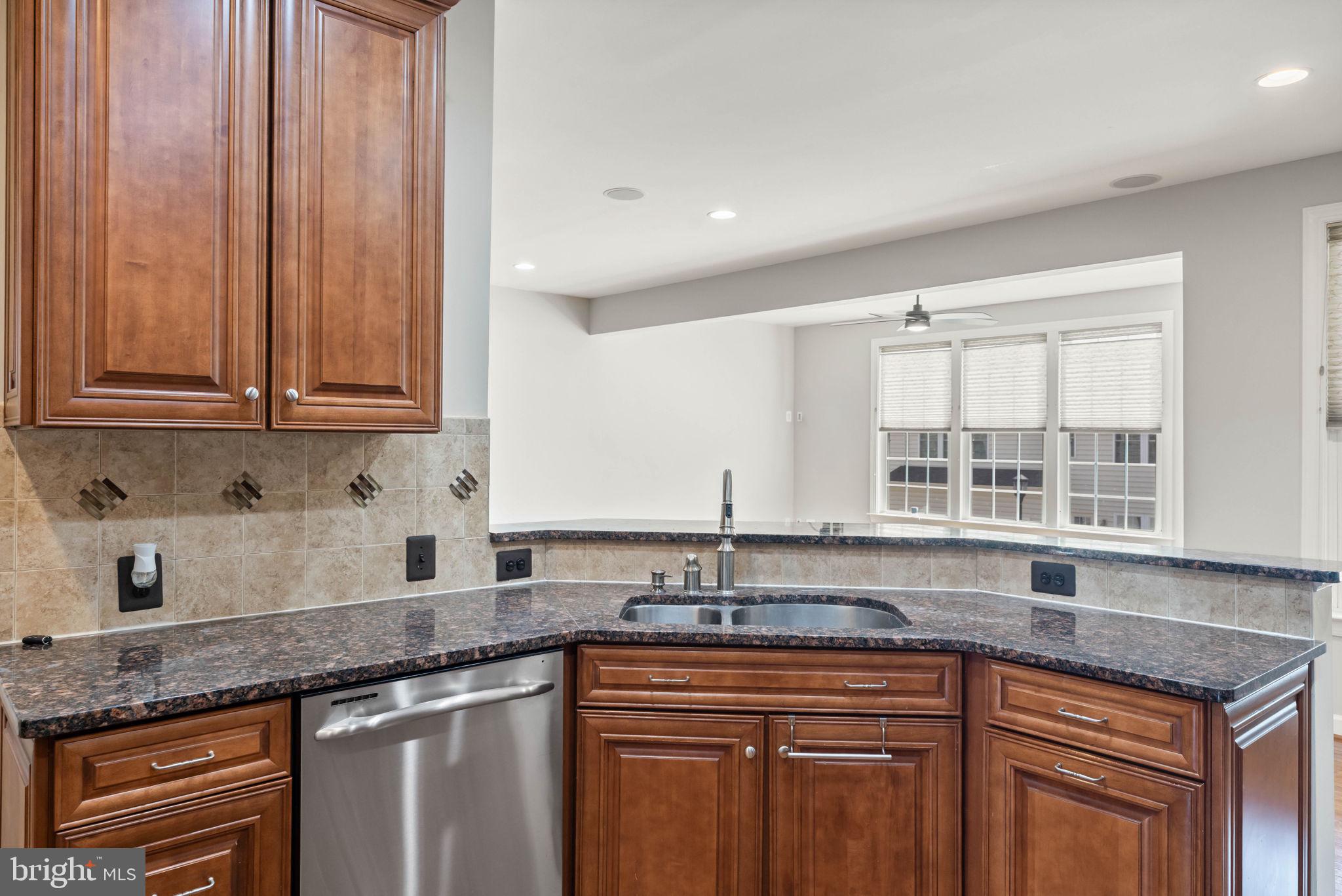 42524 Rowderbury Square Chantilly, VA 20152 - Photo 40 of 73 a kitchen with granite countertop a sink a stove and cabinets