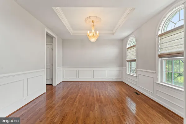 a kitchen with stainless steel appliances granite countertop a refrigerator a stove and a sink with wooden floors