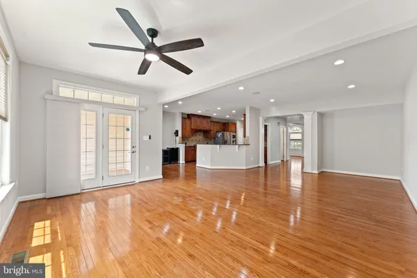 a view of an empty room with window and wooden floor