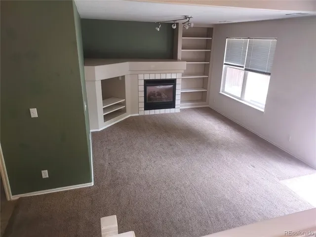 a view of empty room with a fireplace and windows