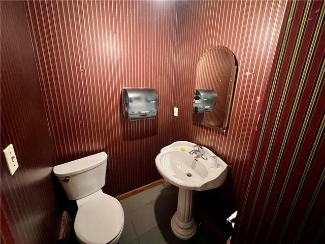 a bathroom with a toilet sink and mirror