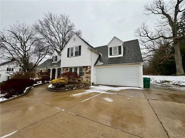 a view of a house with a yard and large trees