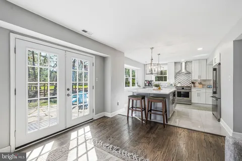 a kitchen with kitchen island a stove a chandelier a refrigerator and cabinets