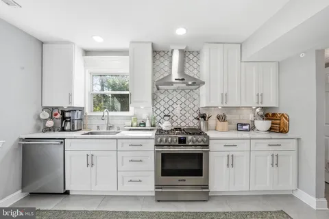a kitchen with kitchen island a refrigerator and a chandelier