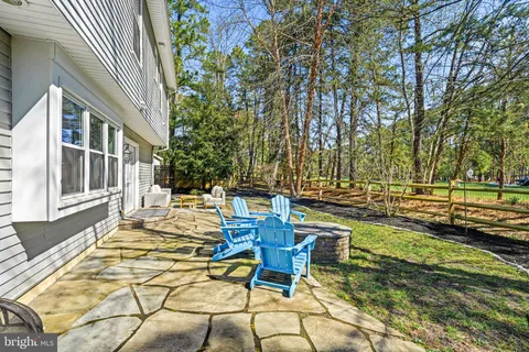 a view of a patio with table and chairs and wooden fence