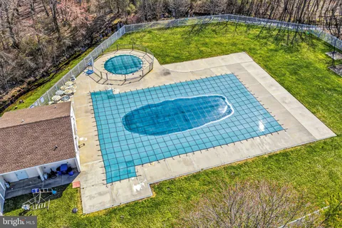 an aerial view of residential houses with outdoor space and trees