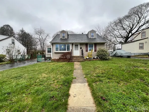 a front view of a house with a garden and trees