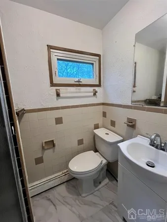 a bathroom with a toilet a sink and mirror