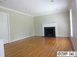 143 McAlway Road Charlotte, NC 28211 - Photo 4 of 8 a view of an empty room with wooden floor fireplace and a window
