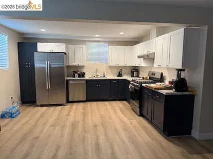a kitchen with stainless steel appliances granite countertop a refrigerator a sink a stove and oven