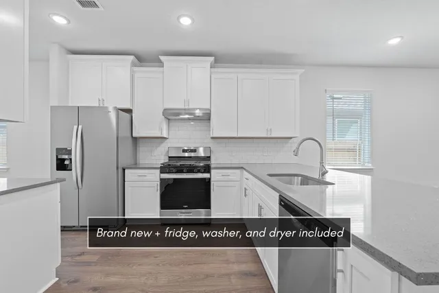 a kitchen with granite countertop a stove and a refrigerator