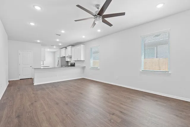 a view of an empty room with kitchen appliances and a window