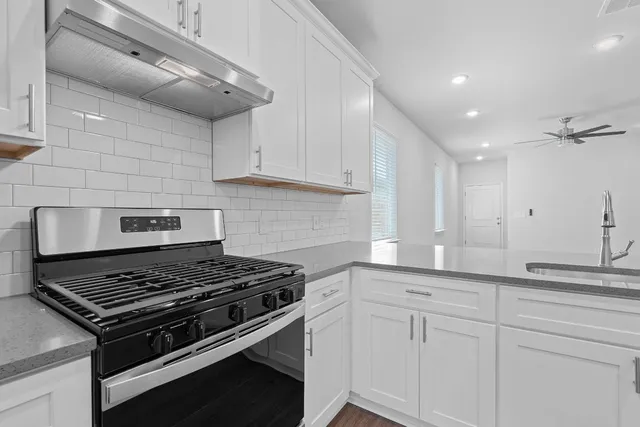 a kitchen with sink stove and cabinets