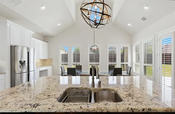 a kitchen with stainless steel appliances granite countertop a sink a stove and a refrigerator