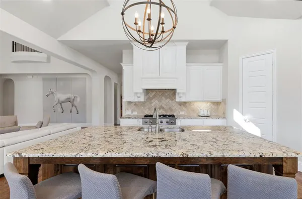 a kitchen with granite countertop kitchen island stainless steel appliances a sink stove and cabinets
