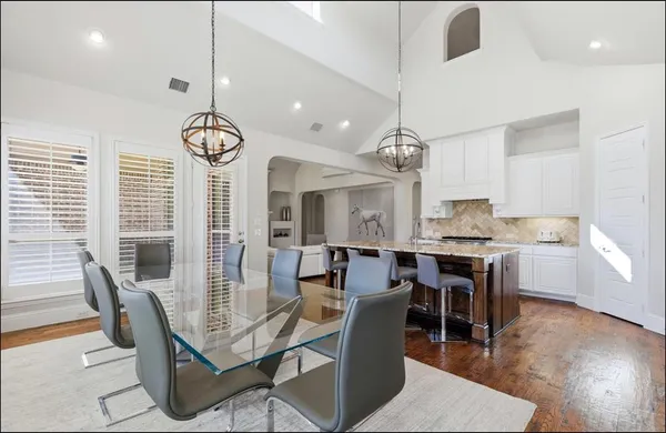 a dining room with furniture a chandelier and wooden floor