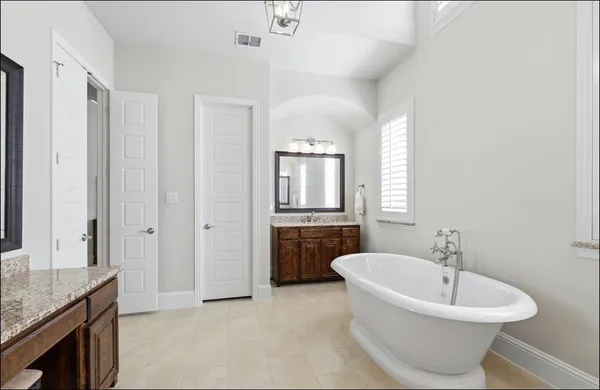 a bathroom with a granite countertop sink and a bathtub