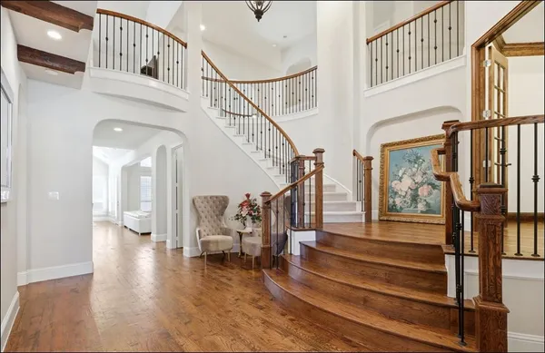 a view of staircase with lots of frames and frames on wall with wooden floor