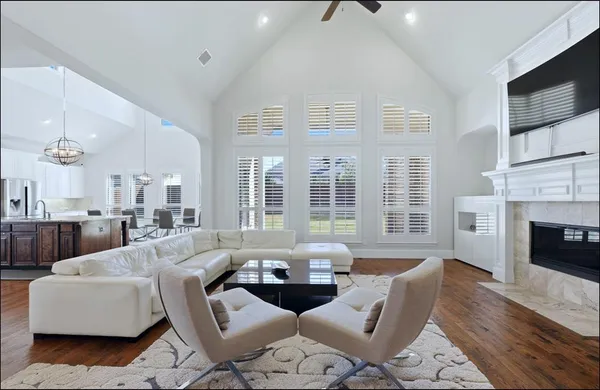 a living room with furniture a fireplace and a large window