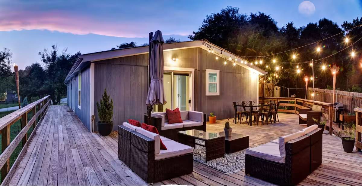 8807 High Valley Road Austin, TX 78737 - Photo 1 of 22 An inviting deck offers generous space for entertaining under festive string lights.