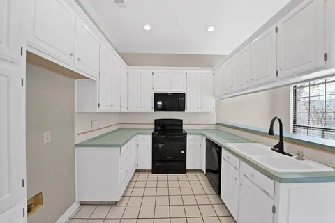 a kitchen with a sink stove and white cabinets