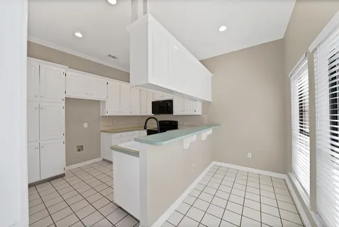 a kitchen with white cabinets and appliances