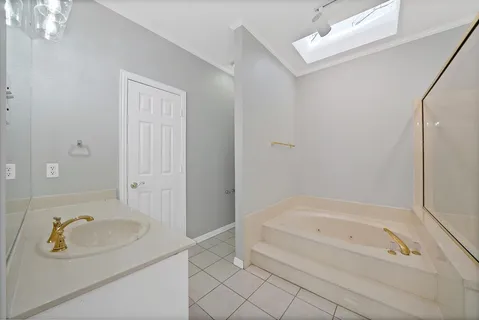 a spacious bathroom with a bathtub shower sink and mirror