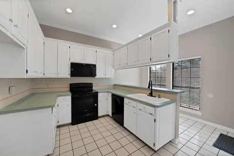 a kitchen with granite countertop a sink stove and cabinets