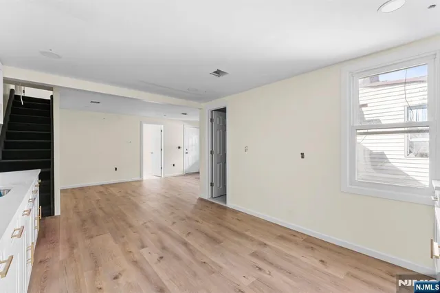 a view of a big room with wooden floor and windows