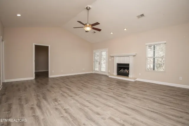 an empty room with wooden floor closet and ceiling fan