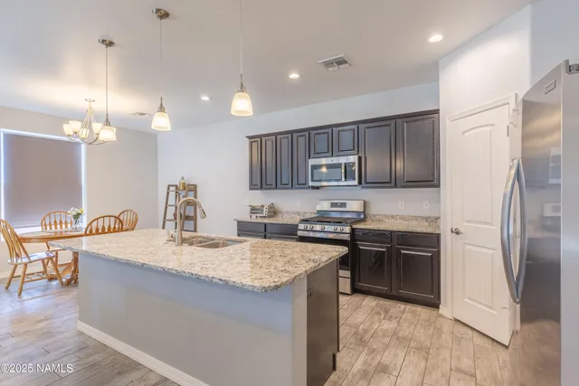 a large kitchen with stainless steel appliances granite countertop a sink stove and cabinets