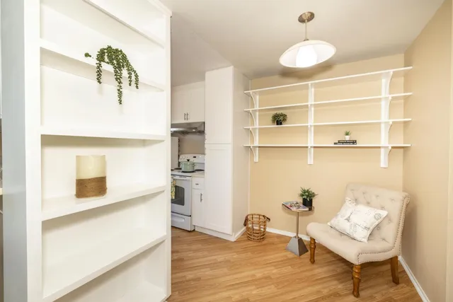 a view of a bedroom with wooden floor and cabinet