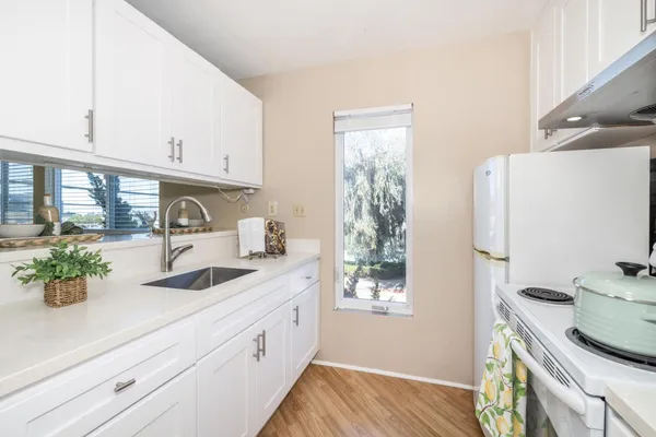 a kitchen with stainless steel appliances a sink a window and cabinets