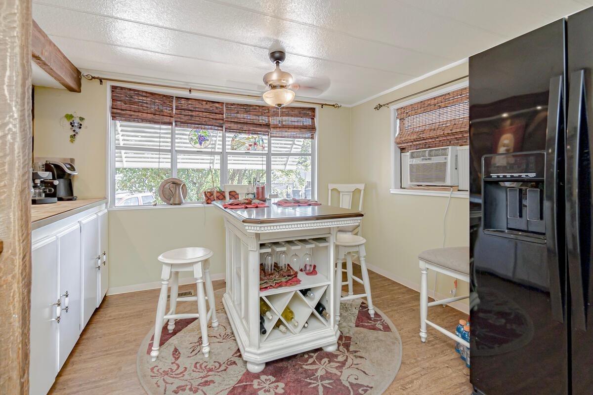 a dining area with chandelier fan and window