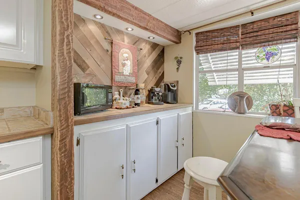 a bathroom with a granite countertop sink mirror toilet and next to a window