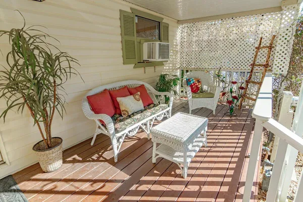 a view of a patio with table and chairs with wooden floor and fence