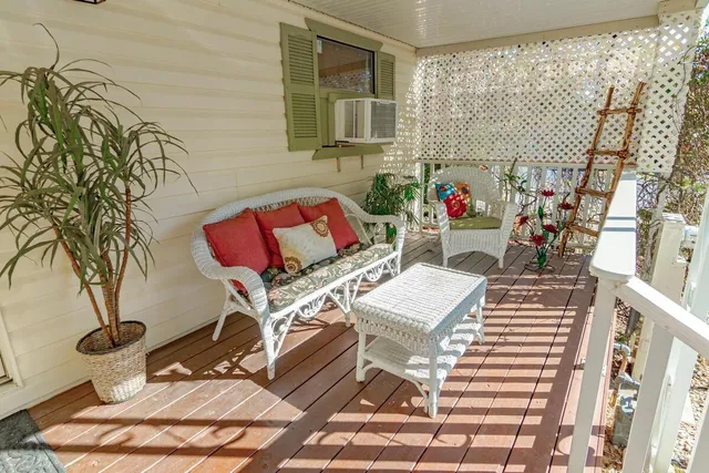 a view of a patio with table and chairs with wooden floor and fence