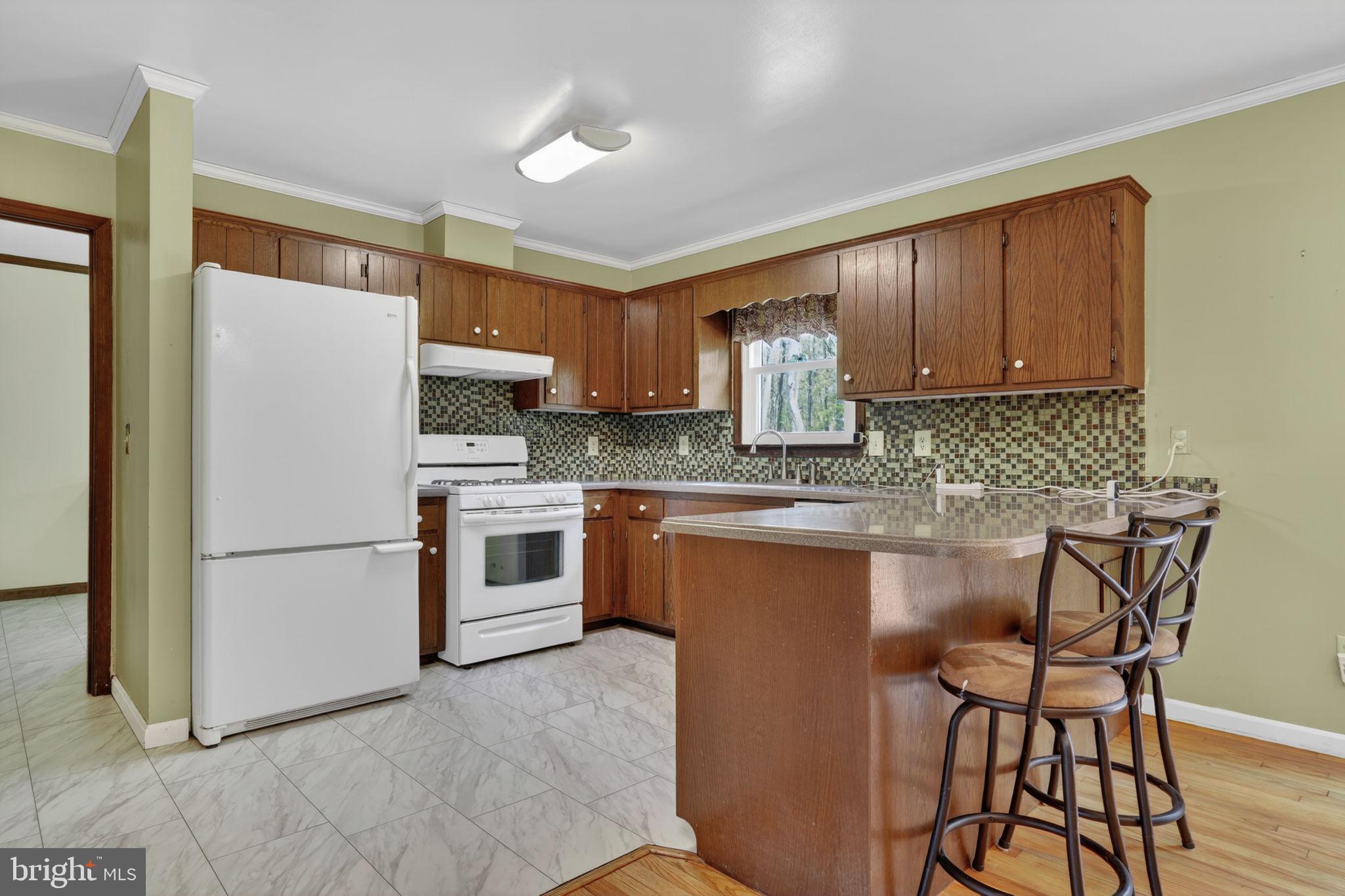14123 Winterville Road Bloxom, VA 23308 - Photo 12 of 84 a kitchen with stainless steel appliances granite countertop a stove a sink dishwasher a refrigerator a microwave oven with cabinets and wooden floor