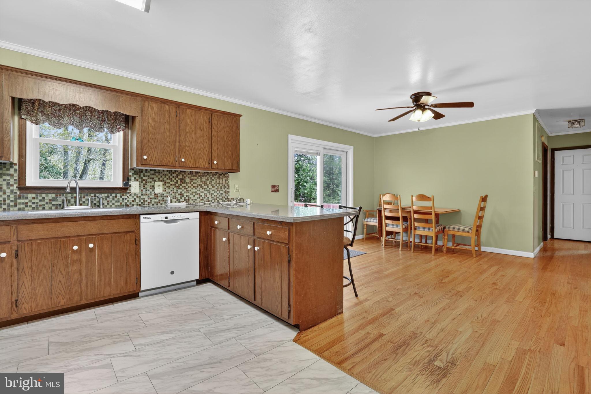 14123 Winterville Road Bloxom, VA 23308 - Photo 15 of 84 a kitchen with stainless steel appliances granite countertop wooden cabinets a dining table and chairs